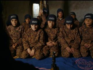 skupina chlapců v maskáčovém oblečení klečí na zemi v místnosti