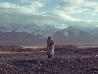 žena stojí a hledí na panorama hor