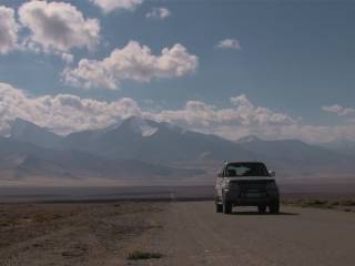 džíp na opuštěné silnici na rozlehlé plání