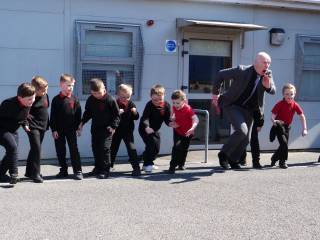 muž a skupina malých chlapců se rozebíhá